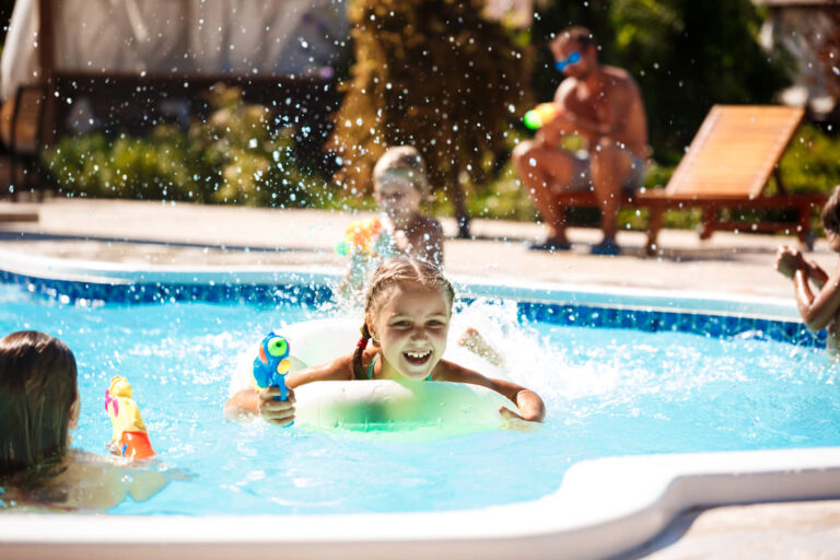 cheerful-children-playing-waterguns-rejoicing-jumping-swimming-pool (1) (1)